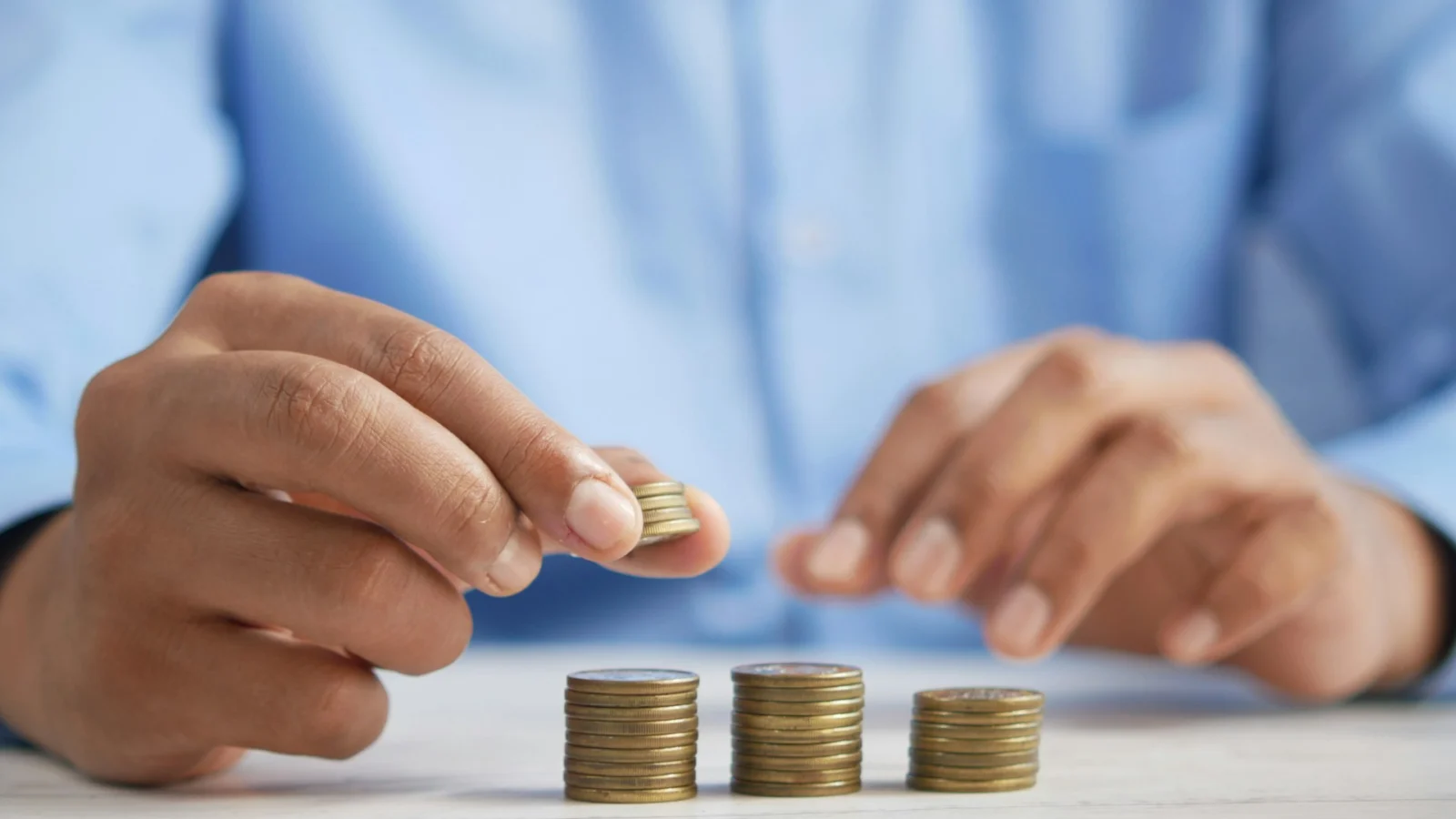 Hands stacking coins on a desk
