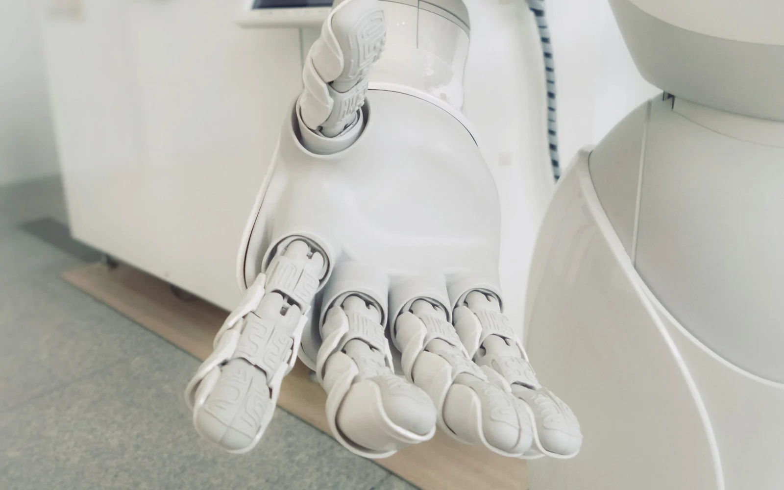White robotic hand with articulated fingers against a pale background