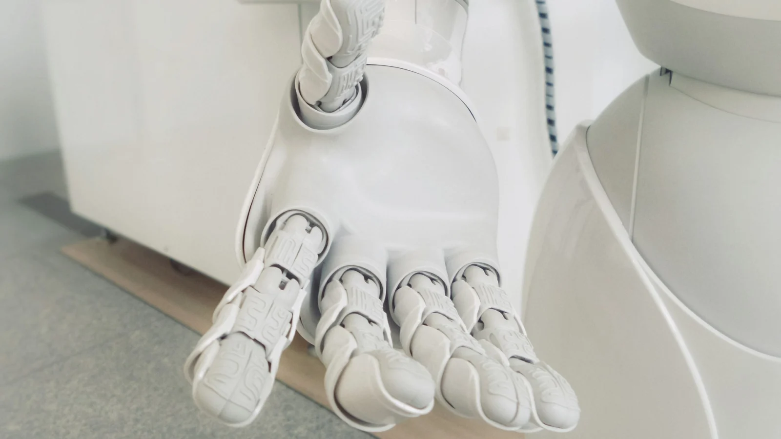 White robotic hand with articulated fingers against a pale background