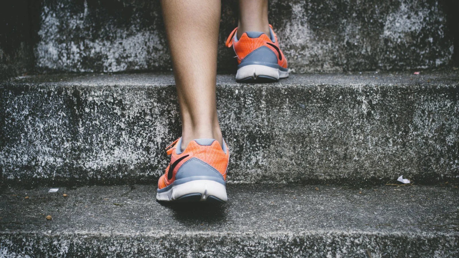 Runner in orange trainers climbing outdoor stone steps